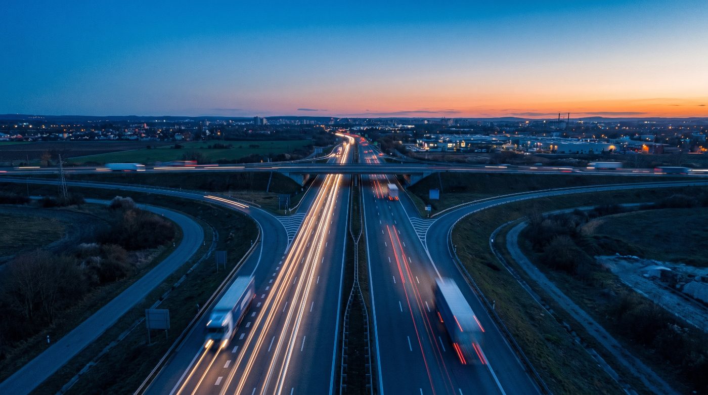 Autoroute au crépuscule et circulation de poids lourds